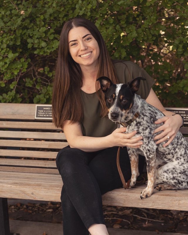 Dr. Kellie Snider sitting on a bench with her dog